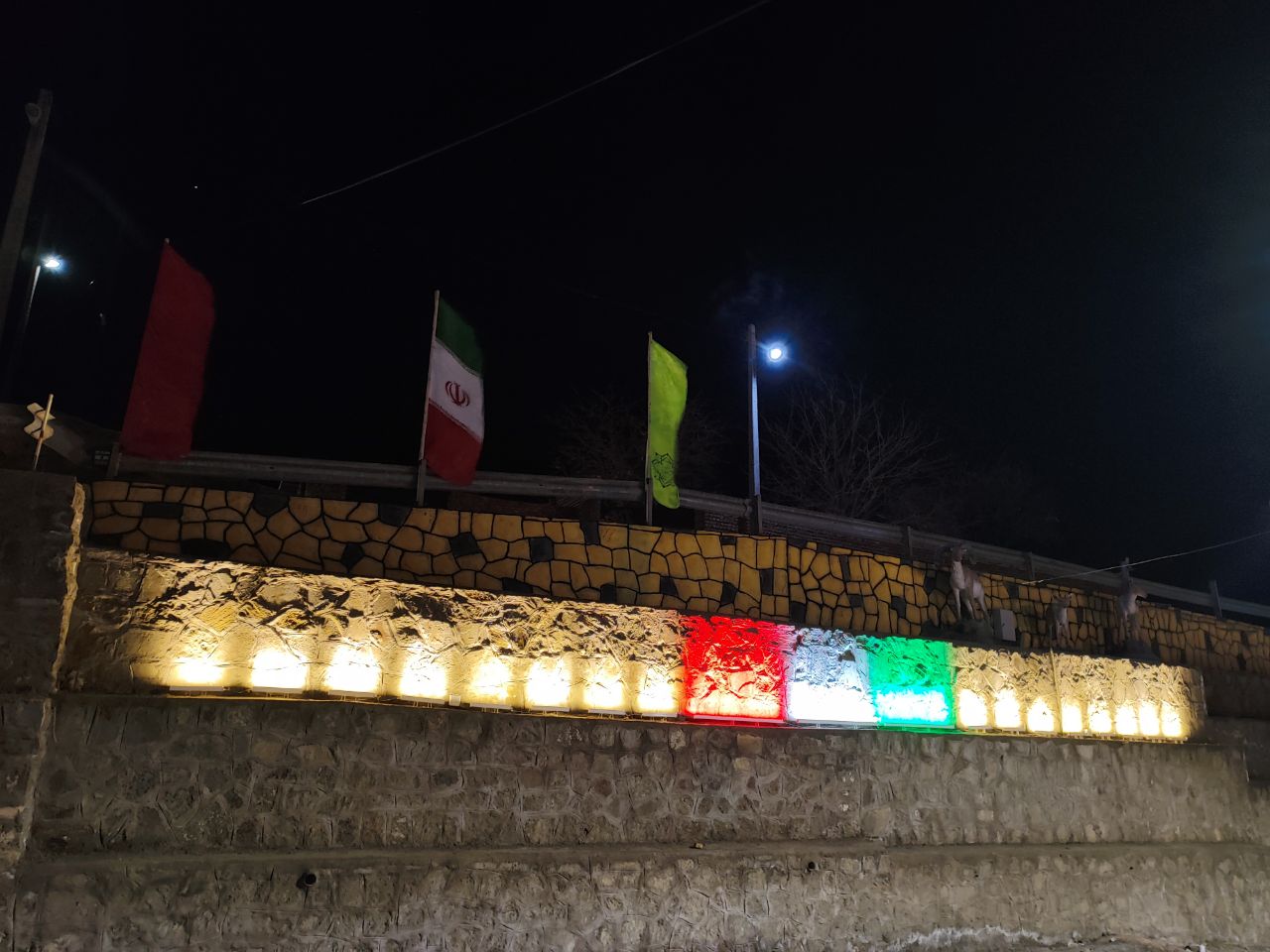 آذین بندی شهر مزداوند به مناسبت ایام الله دهه فجر و اعیاد شعبانیه با ریسه های برنامه پذیر و نصب آذین بندی نورانی با والواشر کم مصرف با طرح پرچم ایران  روی دیوارساحلی
